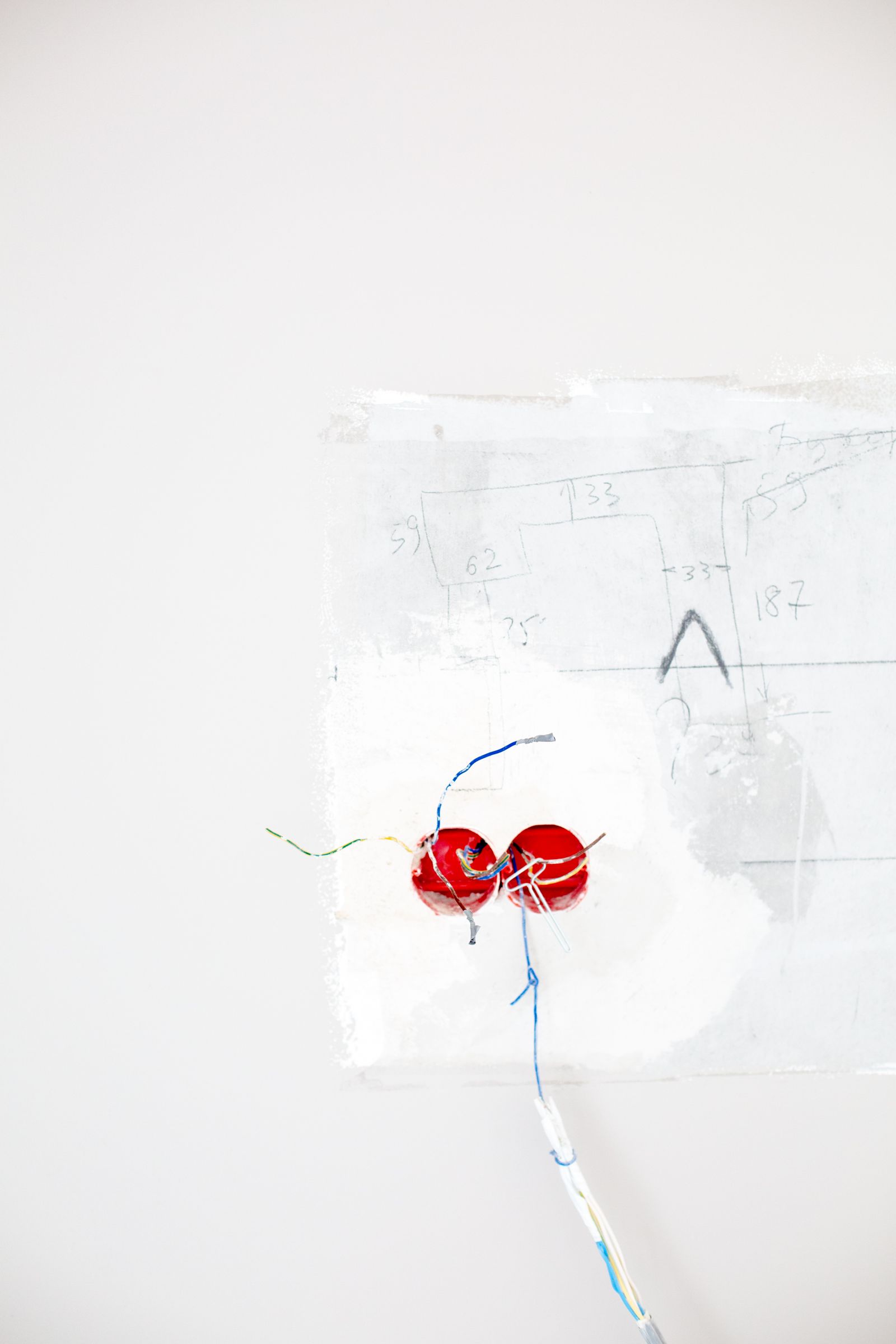 Sample image of red wiring coming out of a white wall