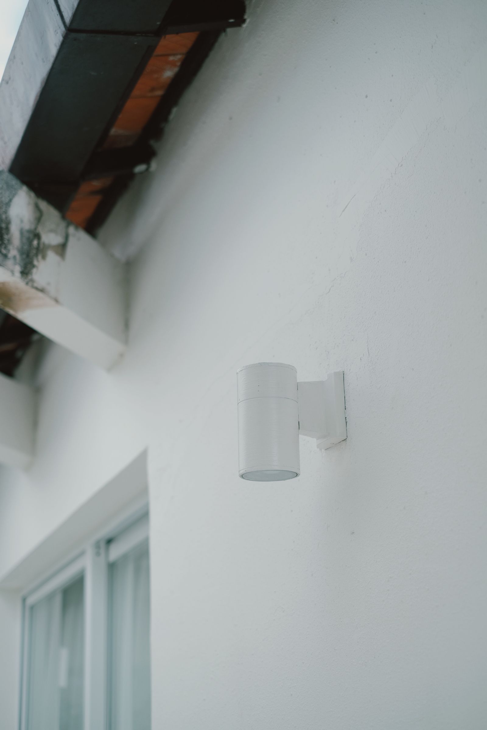 Sample image of a cylindrical outdoor light on a white rendered wall